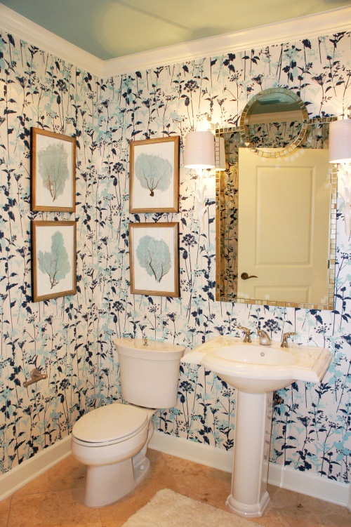 I jazzed up this small bathroom by papering the walls in this fun, blue and white wallcovering and hanging a chic mirror above the pedestal sink.  I flanked the mirror with two white coral Regina  Andrews sconces.